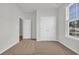 A bedroom features neutral carpet, white walls, natural light, large closet and adjacent room at 389 Sun Colony Blvd., Longs, SC 29568