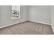 A bedroom features neutral carpet, white walls, natural light, and large window with blinds at 389 Sun Colony Blvd., Longs, SC 29568