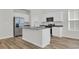 Modern kitchen island with granite countertop, stainless sink and faucet, and white cabinetry for ample storage at 389 Sun Colony Blvd., Longs, SC 29568
