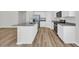Well-appointed kitchen island with granite countertops, stainless sink, and modern faucet on stylish wood-look floors at 389 Sun Colony Blvd., Longs, SC 29568
