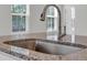 Close-up of granite countertops and modern stainless steel sink with a pull-down faucet in a bright kitchen at 389 Sun Colony Blvd., Longs, SC 29568