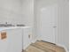 Bright laundry room with wood-look floors, a door to the rest of the home, and wire shelving at 389 Sun Colony Blvd., Longs, SC 29568