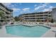 Condominium pool with a sun-soaked pool deck and seating area with an airy and open atmosphere at 1101 Possum Trot Rd. # B302, North Myrtle Beach, SC 29582
