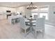 Dining area view of a modern chandelier hanging above a gray circular table with seating for six guests at 115 A 11Th Ave. S, Surfside Beach, SC 29575