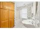 Bathroom featuring decorative wallpaper, toilet, shower with tub, and storage cabinets at 244 George Washington Trail, Georgetown, SC 29440