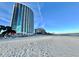 A wide shot of the building taken from the beach showing light sand and a blue sky at 107 S Ocean Blvd. # 808, Myrtle Beach, SC 29577