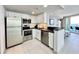 A full kitchen with stainless appliances, white cabinets, and a breakfast bar overlooking the living room at 107 S Ocean Blvd. # 808, Myrtle Beach, SC 29577