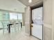 Convenient in-unit laundry closet with stacked washer and dryer; dining area in background at 107 S Ocean Blvd. # 808, Myrtle Beach, SC 29577