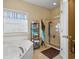 Bright bathroom featuring a corner soaking tub, glass-enclosed shower, and storage shelves for linens at 237 Cloverleaf Dr., Longs, SC 29568