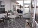 Enclosed porch with a white table and chairs, providing a relaxing outdoor living space at 237 Cloverleaf Dr., Longs, SC 29568