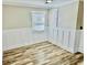 Inviting bedroom with luxury vinyl floors, neutral walls, and white wainscoting at 3936 Murrells Inlet Rd., Murrells Inlet, SC 29576