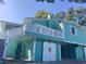 Lovely turquoise coastal home featuring a spacious deck, and white barn doors underneath at 3936 Murrells Inlet Rd., Murrells Inlet, SC 29576