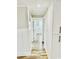 Hallway with wainscoting and luxury vinyl floors leading to a room with natural light at 3936 Murrells Inlet Rd., Murrells Inlet, SC 29576
