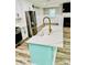 Close-up of kitchen island featuring white countertop, brass faucet, and aqua painted base at 3936 Murrells Inlet Rd., Murrells Inlet, SC 29576