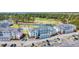 Aerial view of the condo complex featuring a pool, lake, golf course, parking, and well maintained lawns at 4879 Dahlia Ct. # 204, Myrtle Beach, SC 29577
