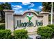 Community sign for Magnolia North with beautiful magnolia logo and landscaping at 4879 Dahlia Ct. # 204, Myrtle Beach, SC 29577