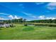 Scenic view of the golf course with a pond and lush green landscape under a bright blue sky at 4879 Dahlia Ct. # 204, Myrtle Beach, SC 29577