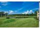 Beautiful golf course view featuring lush green grass, a pond, and mature trees on a sunny day at 4879 Dahlia Ct. # 204, Myrtle Beach, SC 29577