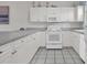 Bright white kitchen with white appliances, grey counters, and neutral backsplash at 4879 Dahlia Ct. # 204, Myrtle Beach, SC 29577