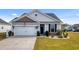 Charming single-story home featuring a two-car garage, stone accents, and manicured lawn at 263 Red Maple Loop, Longs, SC 29568