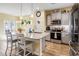 A kitchen with a large kitchen island and granite countertop with gray cabinets and hardwood floors at 263 Red Maple Loop, Longs, SC 29568