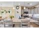 A kitchen with an island featuring pendant lighting and barstool seating; gray cabinets and hardwood floors at 263 Red Maple Loop, Longs, SC 29568
