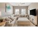 Living room with large sectional sofa, TV, windows, and neutral color palette at 263 Red Maple Loop, Longs, SC 29568