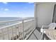 Balcony view with a table and chair overlooking the beach and ocean at 1205 S Ocean Blvd. # 20702, Myrtle Beach, SC 29577