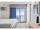 Enjoy the ocean view from the bedroom's balcony through the sliding glass doors and blue curtains at 1205 S Ocean Blvd. # 20702, Myrtle Beach, SC 29577