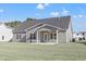 Exterior view of the home showcasing the backyard with a covered porch and a concrete patio at 299 Hayloft Circle, Conway, SC 29526