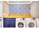 Laundry room with blue cabinets and patterned wall at 752 Kittiwake Ln., Murrells Inlet, SC 29576