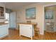 The kitchen features an island with seating, and access to the main door, featuring 