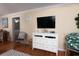 A well-lit living room featuring a wicker chair and a console table with a large television at 1919 Spring St. # B-16, North Myrtle Beach, SC 29582