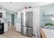 Kitchen with stainless steel refrigerator, white cabinets, wood floor and view to dining room at 2169 Wedgewood Dr., Longs, SC 29568