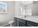 Modern bathroom with dark gray vanity, white countertop, and a large mirror at 307 Hayloft Circle, Conway, SC 29526