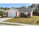 Single-Gathering home featuring vinyl siding, an attached garage, manicured lawn, and partial brick facade at 4659 East Walkerton Rd., Myrtle Beach, SC 29579
