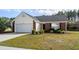 Charming single-Gathering home with a well-manicured lawn, attached garage, and brick accents at 4659 East Walkerton Rd., Myrtle Beach, SC 29579