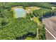 Aerial view of a scenic property featuring a pond, trees, and a dirt road at 7299 Cartrette Rd., Aynor, SC 29511