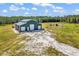 A large barn with multiple garage doors sits on a grassy lot surrounded by forest at 7299 Cartrette Rd., Aynor, SC 29511
