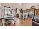Well-lit kitchen with white chairs, stainless steel appliances, and custom wood cabinets at 7299 Cartrette Rd., Aynor, SC 29511