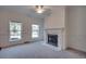 Cozy living room features a fireplace, neutral carpet, and windows offering natural light at 121 Grand Palm Ct., Myrtle Beach, SC 29579