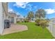 Spacious backyard featuring a concrete patio, well-maintained lawn, and a white picket fence at 133 Junco Circle, Longs, SC 29568