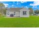 Backyard featuring a grill, windows, and a lush green lawn at 133 Junco Circle, Longs, SC 29568