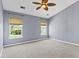 Spacious bedroom with neutral carpet, ceiling fan, and two bright windows at 133 Junco Circle, Longs, SC 29568