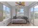 Relaxing sunroom with a comfortable couch, ceiling fan, and large windows offering a serene view at 133 Junco Circle, Longs, SC 29568