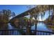Scenic view of a tranquil waterfront with lush trees and a charming bridge in the background at 2327 King Farm Rd., Aynor, SC 29511