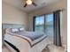 Comfortable bedroom with a ceiling fan and a large window with blinds and curtains at 2557 7B Pete Dye Dr. # 704, North Myrtle Beach, SC 29582