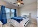 Cozy bedroom with a ceiling fan, a large window, and a comfortable bed with blue accents at 2557 7B Pete Dye Dr. # 704, North Myrtle Beach, SC 29582