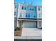 A townhouse showcasing stone and siding, a garage, and a well-kept lawn at 2557 7B Pete Dye Dr. # 704, North Myrtle Beach, SC 29582