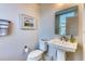 Well-lit half bathroom featuring a pedestal sink, toilet, and decorative mirror at 2557 7B Pete Dye Dr. # 704, North Myrtle Beach, SC 29582
